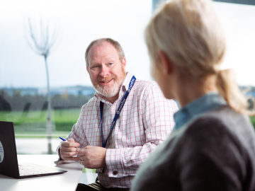 Zaposlenik Eurofins Biopharma Product Testing objašnjava klijentu postupak stabilnosti i skladištenja. Scena prikazuje profesionalnu interakciju u uredu tvrtke, naglašavajući stručnost, suradnju i detaljno vođenje kroz postupke testiranja stabilnosti.