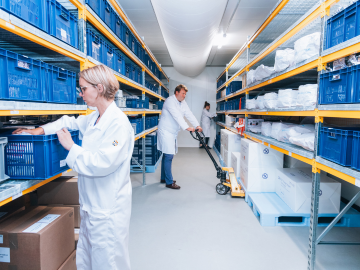 Troje laboratorijskih tehničara premještaju materijale s polica u jednom od skladišnih prostora Eurofinsa. Scena naglašava organizaciju, preciznost i kapacitet skladištenja u rukovanju materijalima za testiranje dugoročne stabilnosti.