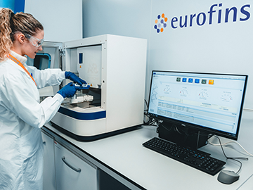 Laboratorijska tehničarka, koja nosi rukavice i zaštitne naočale, sprovodi mikrobiološke testove koristeći najsuvremeniju opremu u laboratoriju Eurofins BioPharma Product Testing.